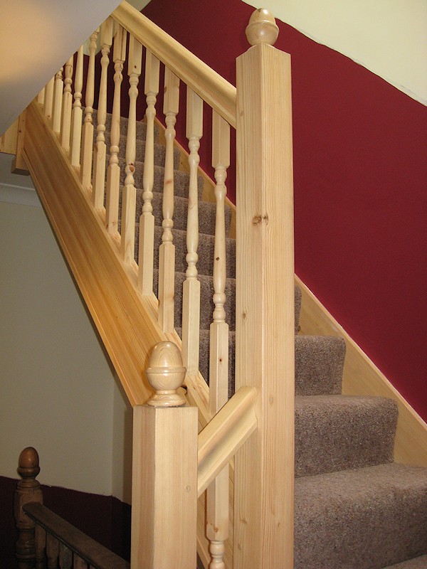 A softwood single turn winder staircase for a loft conversion, all left in natural pine with a clear varnished finish.