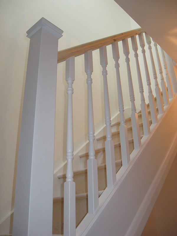 A softwood staircase for a loft conversion, painted white with feature pine handrail.