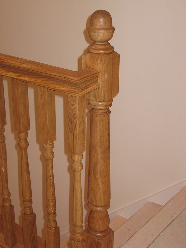 A simple straight flight staircase between enclosed walls, brought to life with oak balustrade on landing.