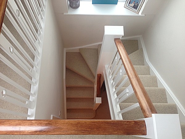 A clockwise softwood staircase with six winders around a central double newel post.