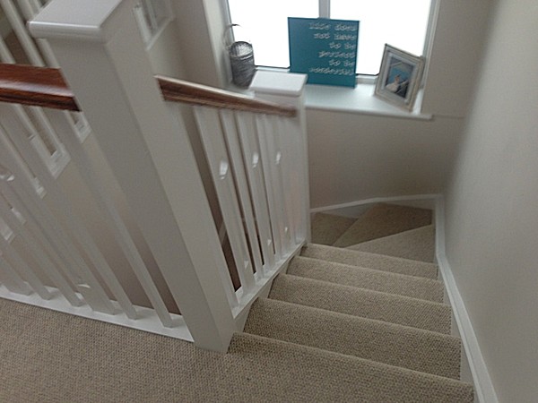 A clockwise softwood staircase with six winders around a central double newel post.