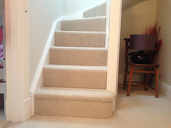 A clockwise softwood staircase with six winders around a central double newel post.