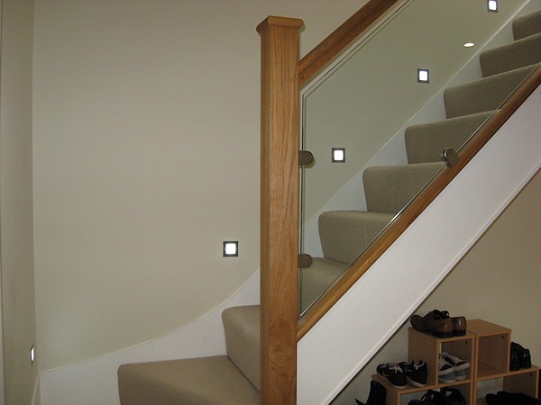 This staircase has an ultra modern feel with glass balustrade and lighting mounted above the wall string.