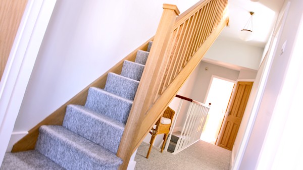 Oak staircase with our std profile handrail, square 32mm spindles and pyramid newel caps.