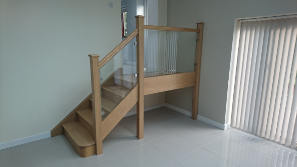 Small oak construction staircase with glass infill panels.