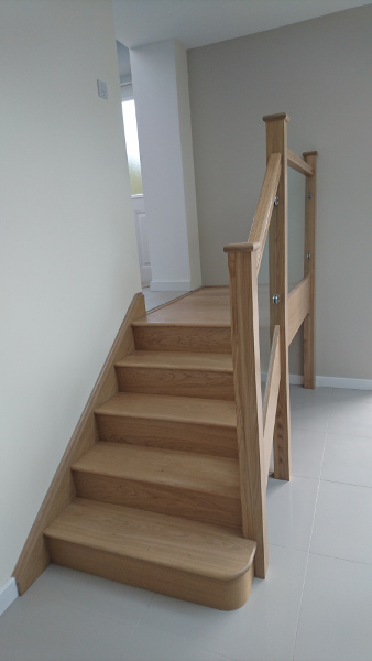 Small oak construction staircase with glass infill panels.