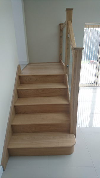 Small oak construction staircase with glass infill panels.