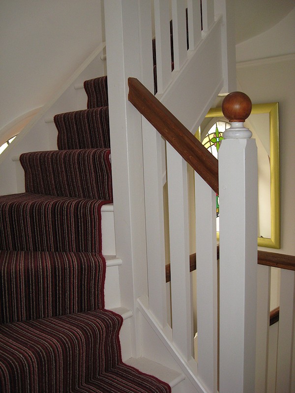 This softwood double winder staircase was for a loft conversion, painted white with a carpet runner.