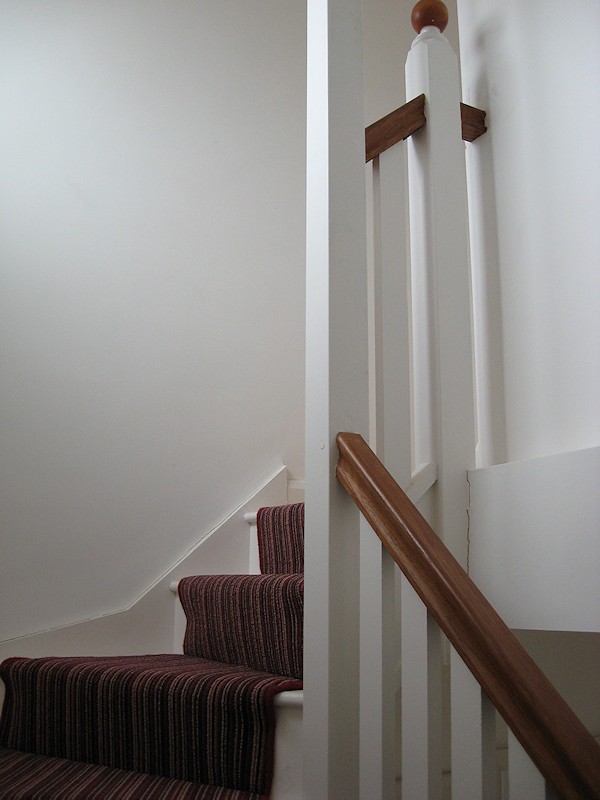 This softwood double winder staircase was for a loft conversion, painted white with a carpet runner.